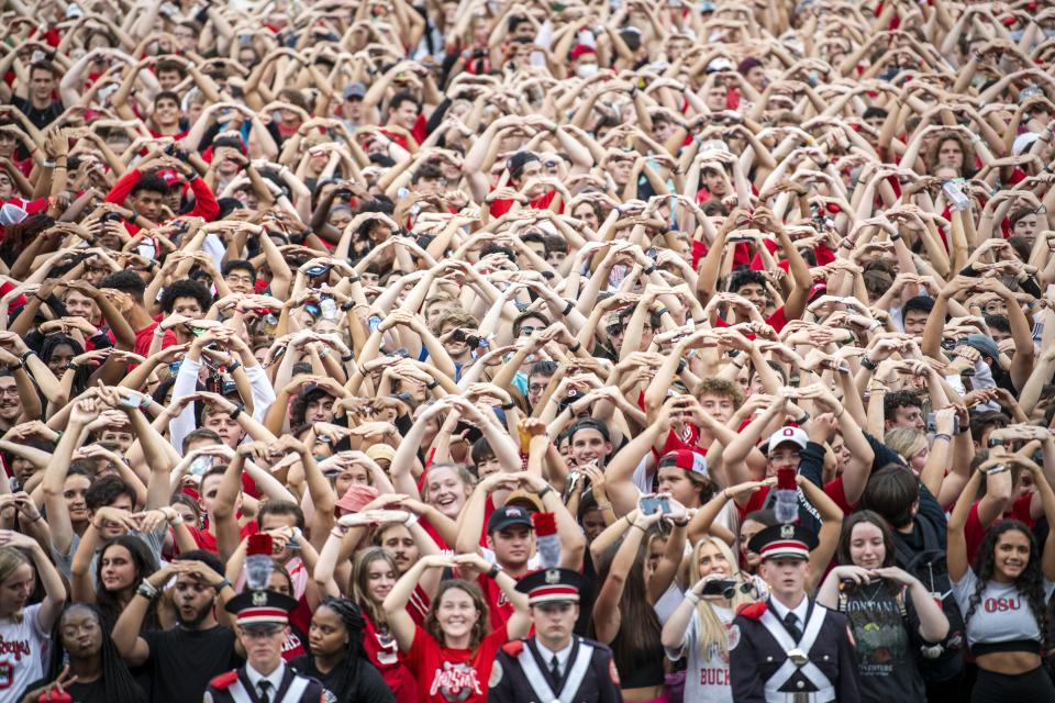Fans making an O with their arms